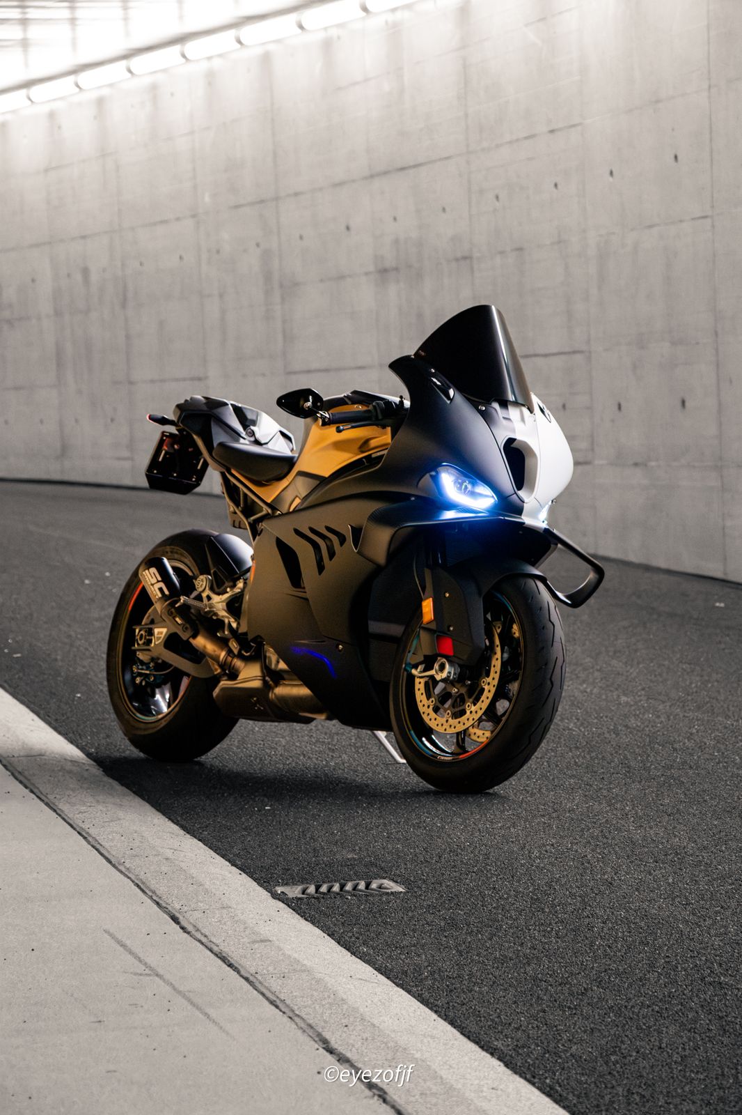 Oranges BMW-Sportmotorrad mit Licht in einem Betontunnel